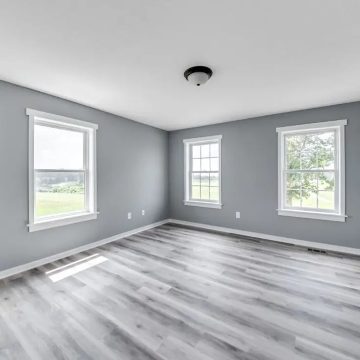 Dormitorio vacío con piso vinílico gris símil madera y zócalos blancos