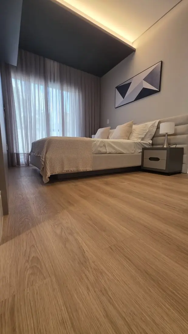 Dormitorio con piso vinílico color roble natural visto desde el nivel del piso